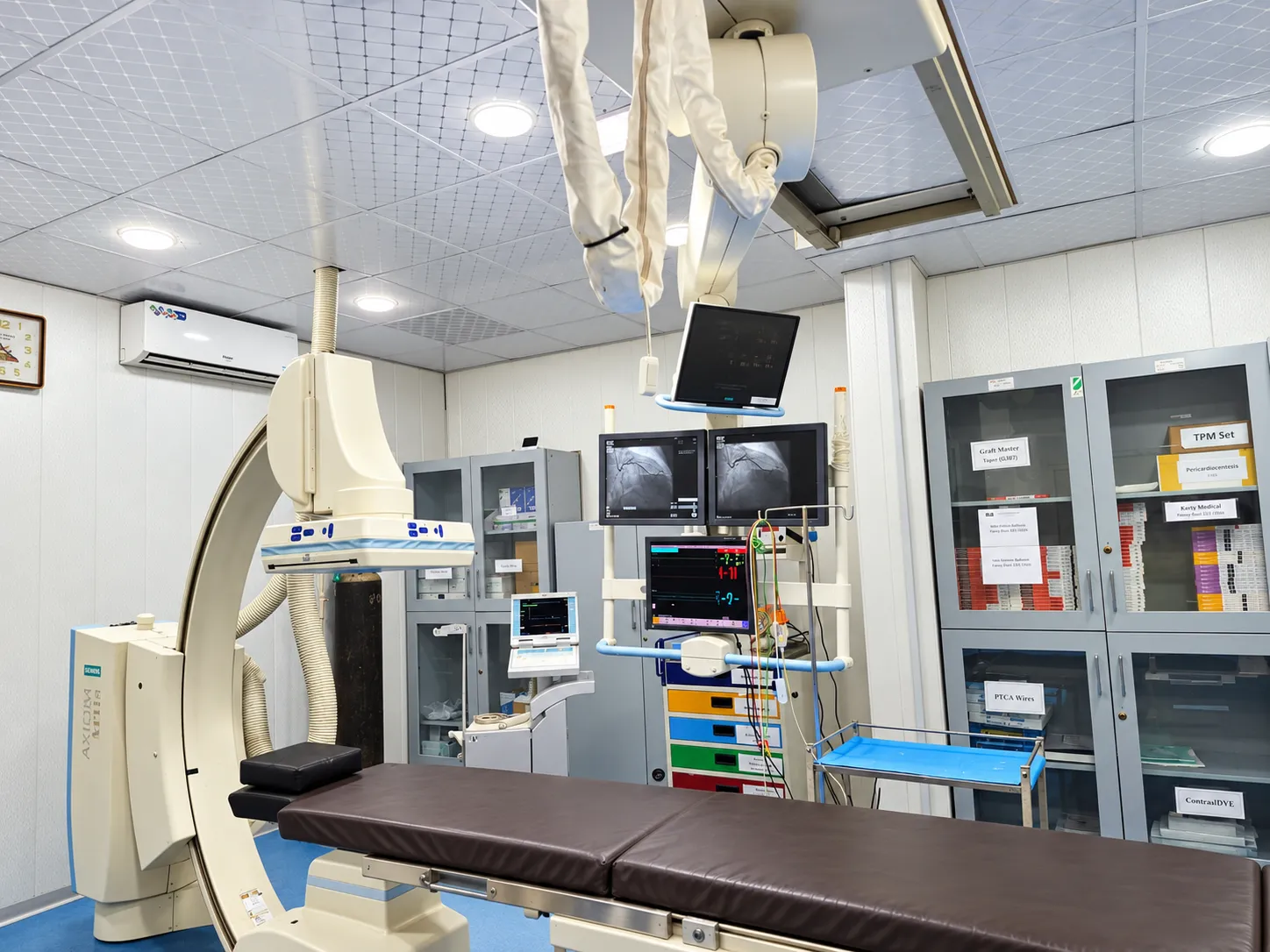 Cardiac catheterisation laboratory with imaging equipment and monitors