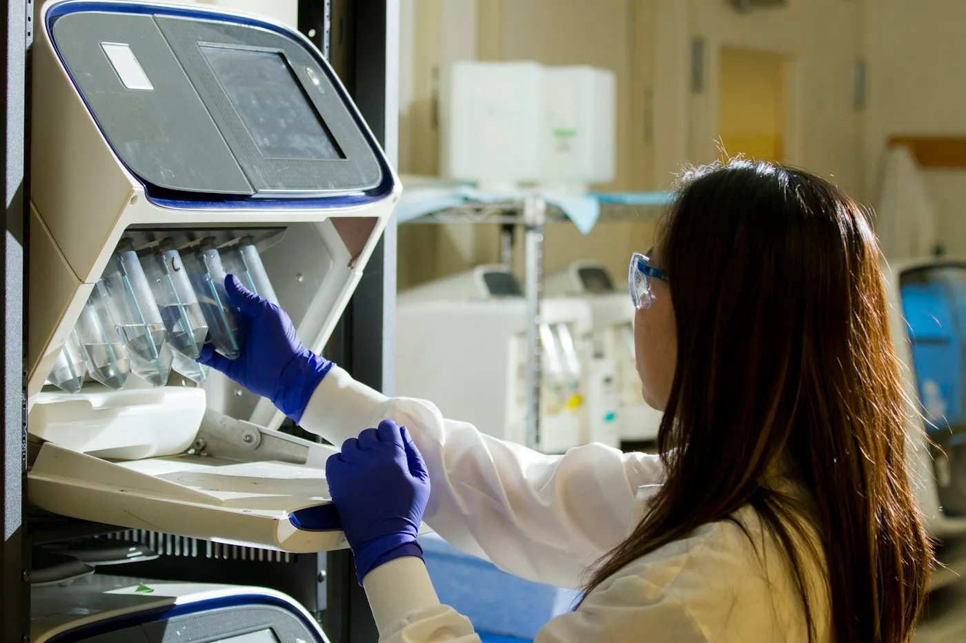 A technician loading samples into an analyser